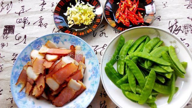 蒸好的腊肉切片；荷兰豆摘去老筋洗净；小米椒切斜段；葱姜蒜切末