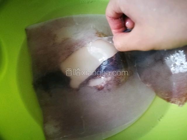 撕掉鱿鱼表面的黑膜，把鱿鱼冲洗干净
