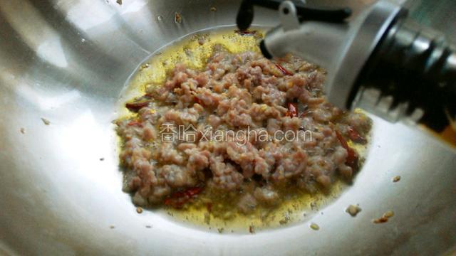肉末变色后锅边淋入料酒，翻炒均匀