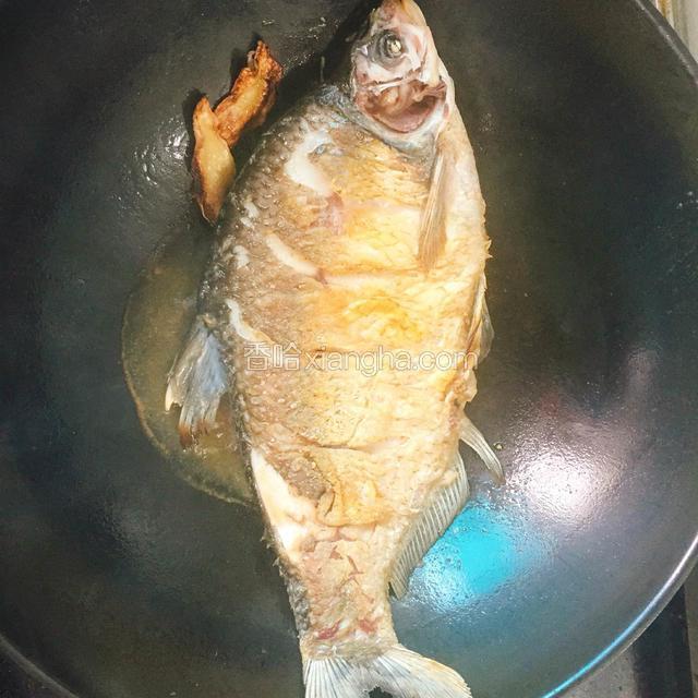 用中火煎至，不时晃动锅 使鱼面都能受油热，待到鱼面金黄时翻鱼煎至另一面
