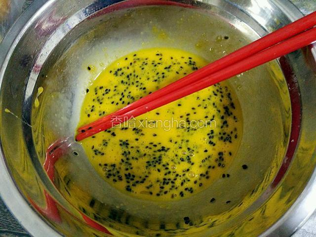 鸡蛋敲入碗中，加适量黑芝麻，一点点细砂糖，搅拌均匀