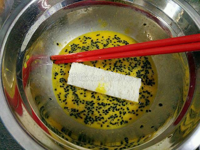 放入一个面包条迅速裹上蛋液后夹出
