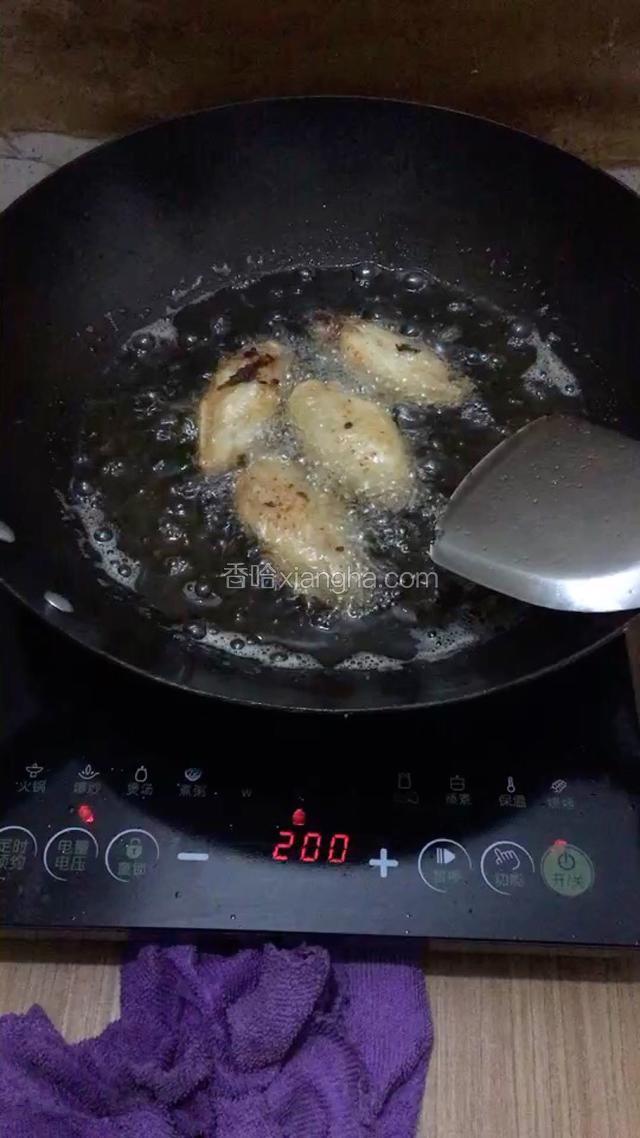 20分鐘后把雞翅再次攪拌，鍋裡放入適量的調和油（花生油）開大火燒開，燒至4成熱放入雞翅開始油炸，（不可以把雞翅一次放入熱鍋內，不好控制）