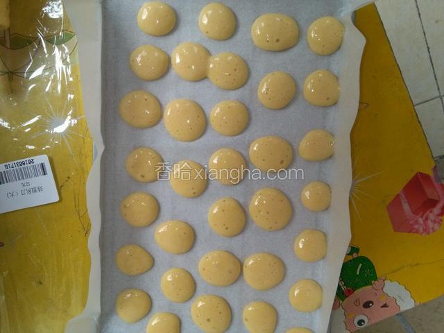在不粘烤纸上挤出小圆点面糊