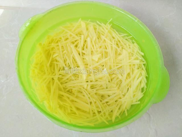 土豆切细丝，放盆里洗两遍再放盆里，用清水浸20分钟，之后沥去水备用