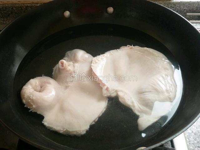 锅里放水烧开，猪肚片成两半煮半20分钟