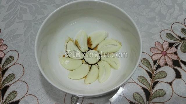 取一只碗，碗底铺上蒜片。