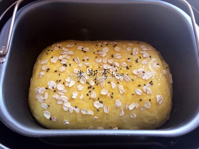 快速撒上麦片和黑芝麻，合好上盖，继续进行烘烤；
