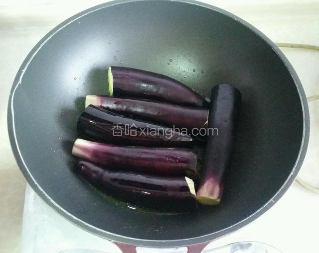 锅内放比平时炒菜多些的油烧至六成热，放入茄子开始煎；