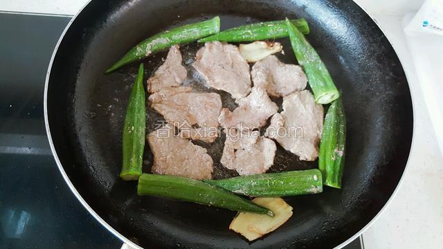 在翻面煎制时锅中会有牛肉汁水淌出，这时下入秋葵进行煎制，并不断翻转秋葵，使之均匀，同时撒适量盐。