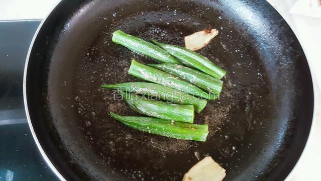 翻煎锅中秋葵，使牛肉汁水充分粘均匀。