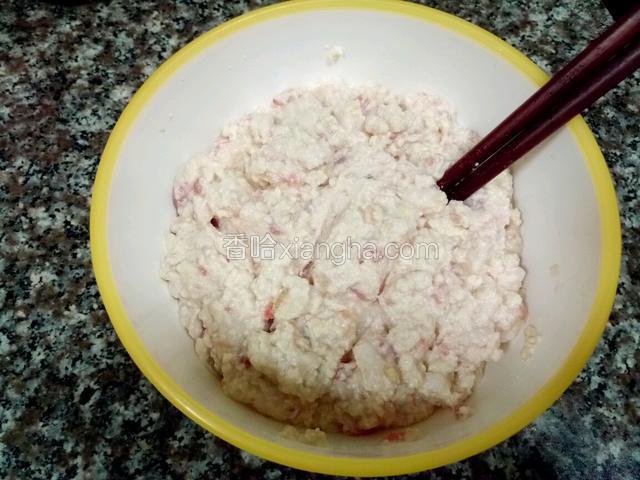 用筷子将肉馅和豆腐碎沿顺时针方向搅拌均匀。