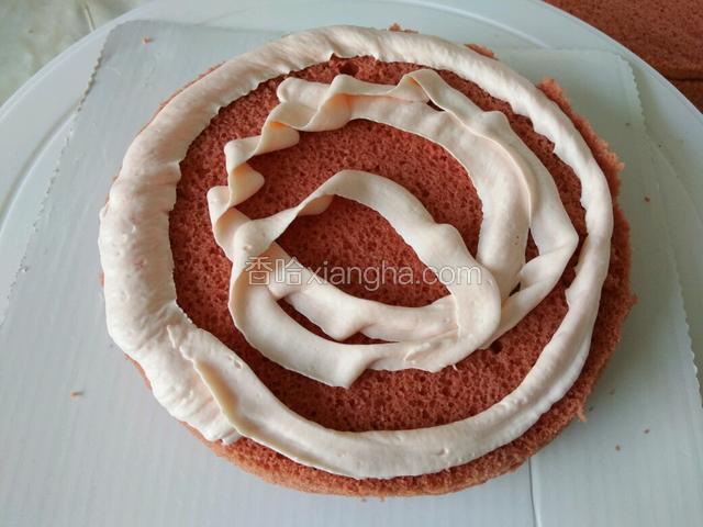 取一片蛋糕，用裱花袋挤上一圈奶油，当然这一圈奶油可以用原味的，也可以添加草莓果酱。