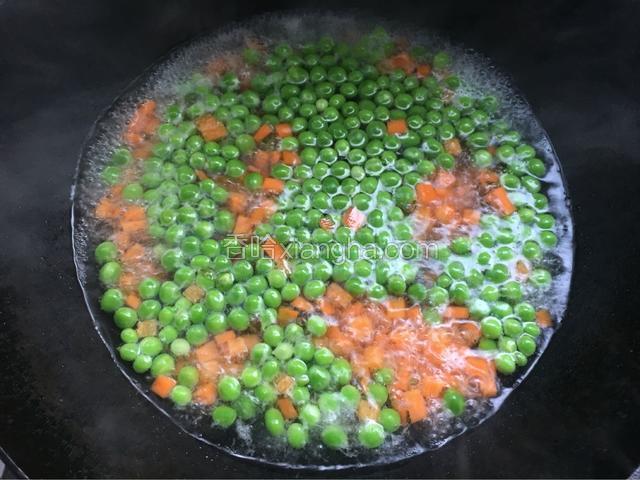 倒入红萝卜和青豆焯水一分钟。