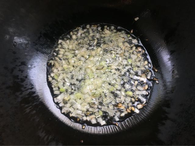 接着把锅洗净，烧热，倒入花生油，爆香蒜蓉和葱碎。