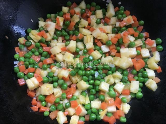 倒入红萝卜、青豆和菠萝翻炒一下。