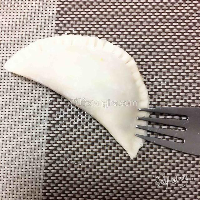 饺子皮放肉末对折，用叉子按出边花