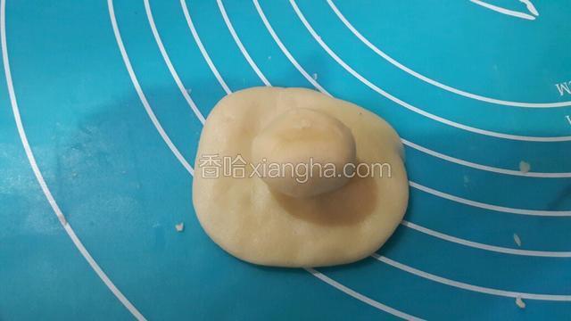 取一个水油皮面团，幹平，当中包入油酥面团，捏紧收口。