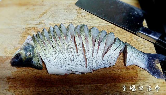 武昌鱼洗净后，去掉鱼鳍，头尾分开，鱼段部分从鱼背处下刀，切成一厘米左右宽的鱼片，中间脊背切断，鱼肚不能切断。