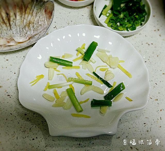 取出大一点的盆，盆底撒入适量的蒜片，姜丝，和葱段。