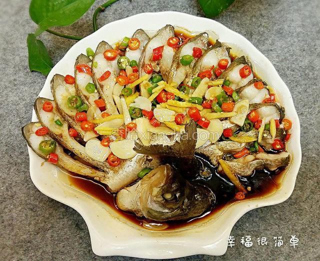 时间到后，取出鱼盘，倒尽汤汁，用筷子挟出露在表面的葱，姜。在鱼表面上均匀地撒上糖，鸡精，生抽和 蒸鱼豉油。再均匀地撒上小米椒和藤椒。再撒上剩余的姜丝和蒜片。另起一锅，倒入适量的清油，烧到七八成熟的时候，浇到鱼上面。