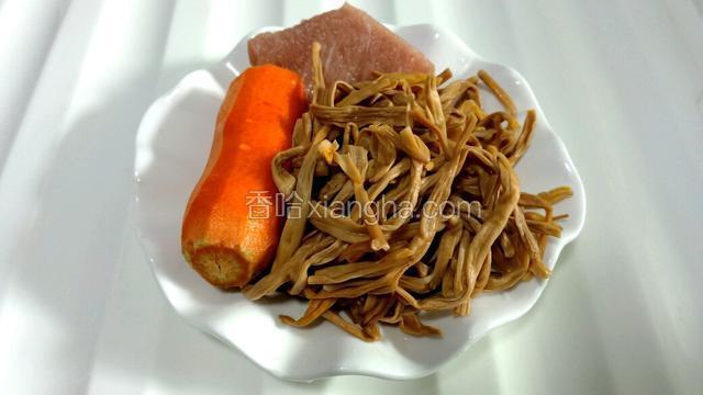将黄花菜洗净后在温水中浸泡15分钟，再控干水份，把胡萝卜、猪肉洗净。