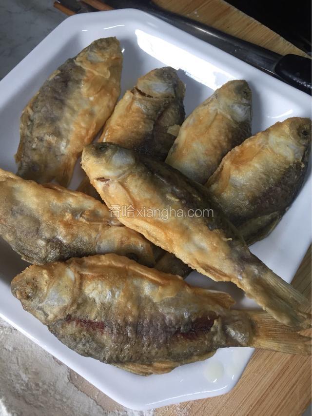 煎好的小鱼控油后装盘备用