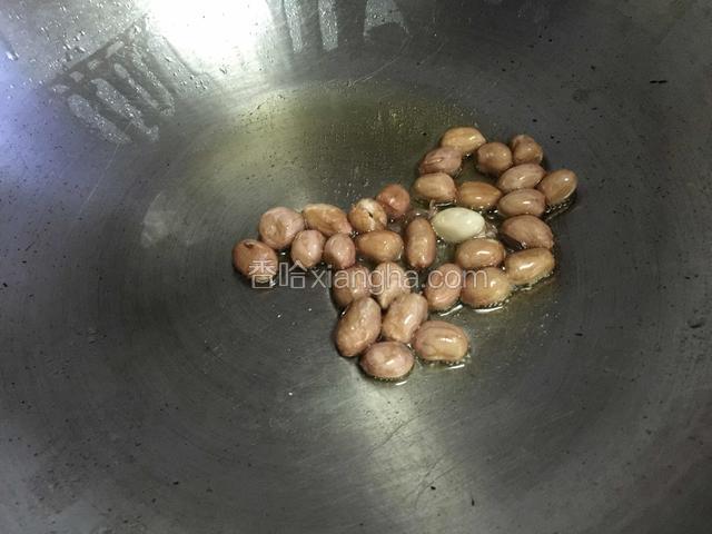 炖土豆时准备其他材料。花生米放油锅内炒熟备用。