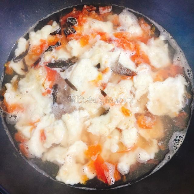 依次将面片疙瘩揪好放入锅中 ，点一点清水，待水再次滚开放入木耳