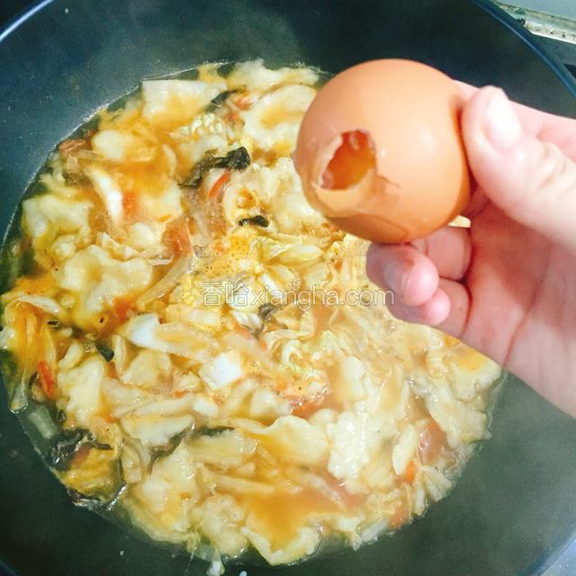 待面片与菜熟后，将鸡蛋打开一个小口，将鸡蛋甩进锅中