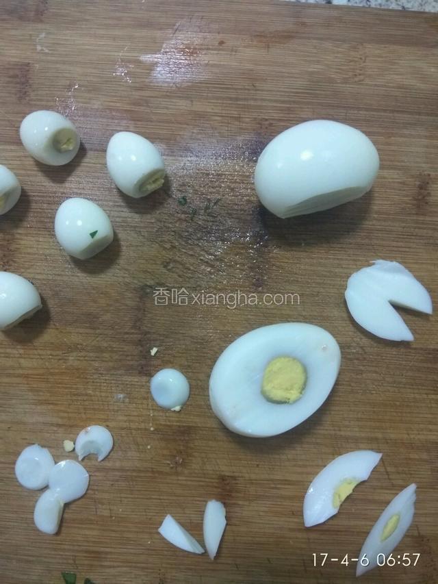 鹌鹑蛋、鸡蛋煮好后剥皮，鹌鹑蛋用小刀切去底部，在鸡蛋侧面切一刀下来。切下来的鸡蛋片（切一个三角△）做小白兔的耳朵。从鸡蛋小头横着切一刀后把小白兔的耳朵放进去，用黑芝麻做小白兔的眼睛，小白兔就做好了一只，另一只也这样做。