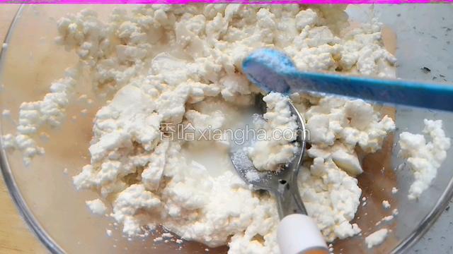 晾凉的豆腐用勺背压碎，加入盐和糖，搅拌均匀。