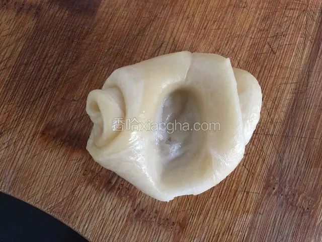 取出醒好的面团用食指用力朝中间部分按下