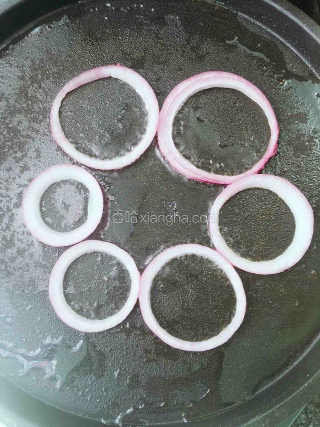 平底锅预热刷油，放入洋葱圈。