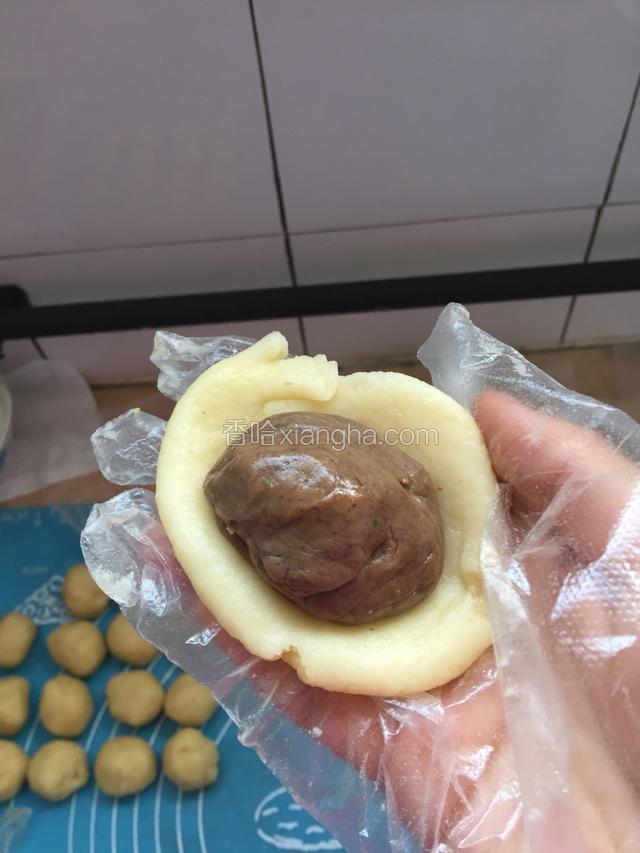 包好的豆沙放入擀好的油皮中包好