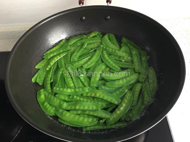 荷兰豆去筋洗净。锅加适量清水烧开倒几滴油放荷兰豆再次烧开荷兰豆变色捞出。