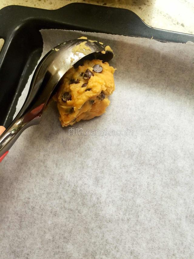 开始预热烤箱170度10分钟，烤盘上铺油纸，我用的是挖冰淇淋的勺子挖出一个球，放入烤盘，然后压扁