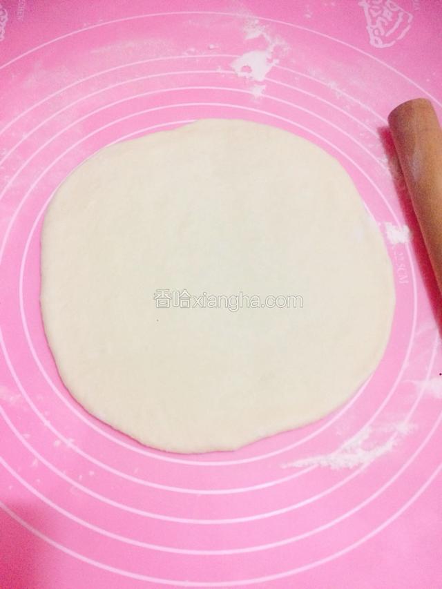 把面团用擀面杖擀成披萨盘大小的饼皮。