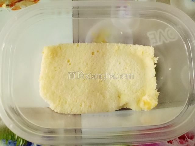 做好的戚风蛋糕片成三片，取一片按盒底大小裁剪成两块，先放一块蛋糕在盒子里。