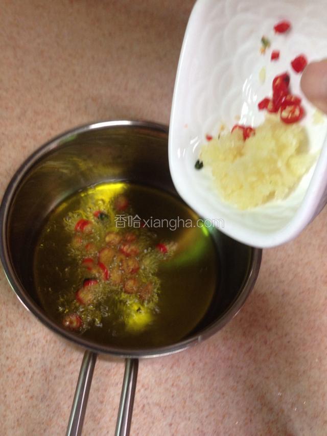 油温滚热后关火离灶放入小米辣和蒜末，利用余热爆香。