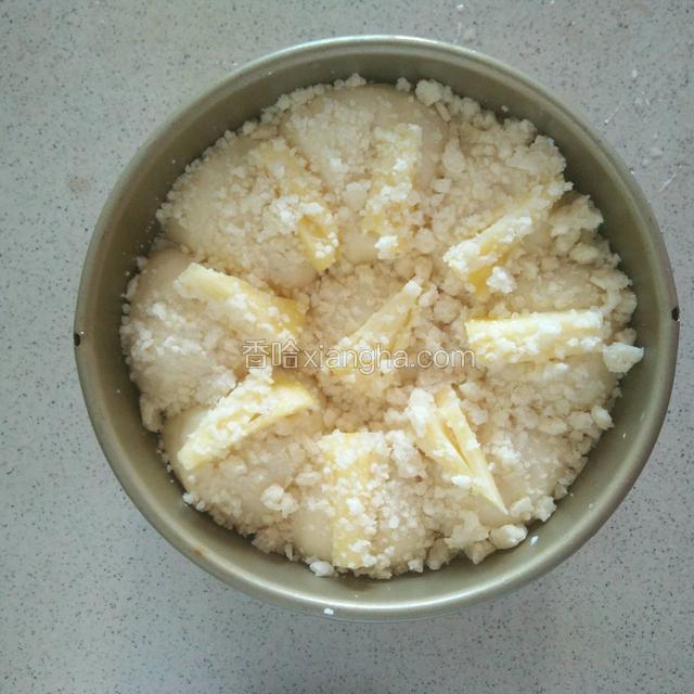 发酵好的面团，摆上菠萝，用手按压一下，使菠萝溶入面团中，刷上少许纯牛奶，撒上起酥粒，菠萝只需一小块就可以了，放入烤箱中180度上下火烤25分钟,就可以了