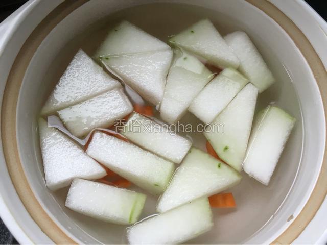沙煲放大半煲水，放入冬瓜和红萝卜先开大火煮。