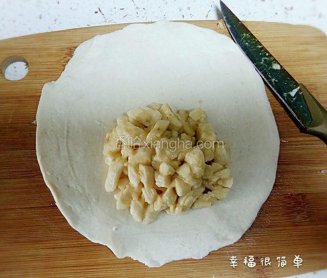 速冻里拿出手抓饼，过两分钟整理一下，把香蕉碎放在饼皮的一边。