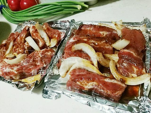 烤盘中铺好锡纸 将腌好的肋排摆放好 洋葱也均匀放好