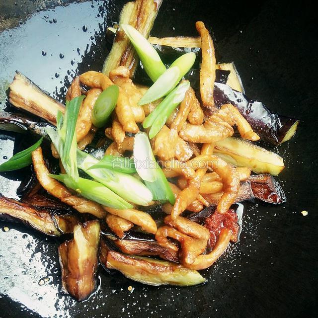 再加入炸好的茄子和炒好的肉丝，放入葱段