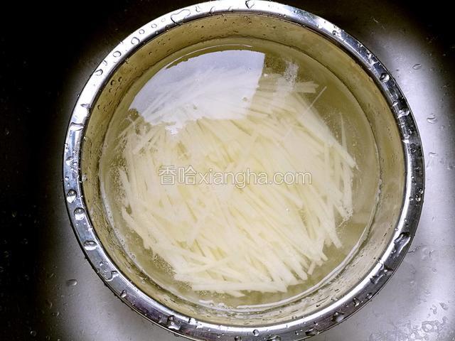 用清水将土豆丝泡去淀粉。(这样炒出来的土豆丝清爽不粘)。