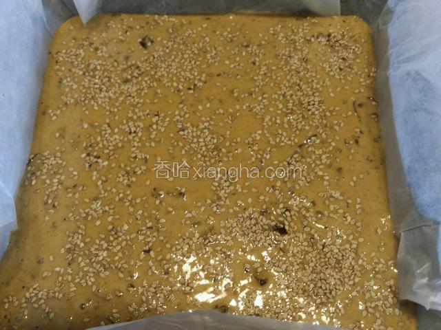 烤箱150度预热，模具铺油纸，倒入枣糕糊，撒上芝麻，140度烤50分钟