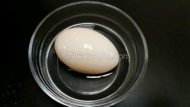 取一个鸭蛋放在酒里滚一圈。