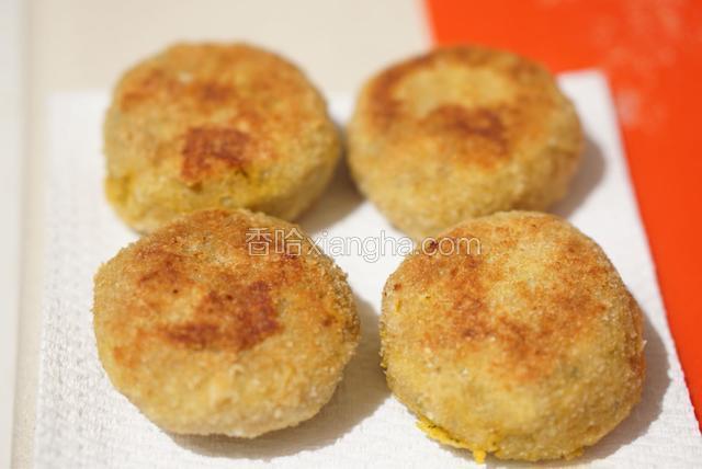 煎好的饼放在纸巾上吸掉过多的油。