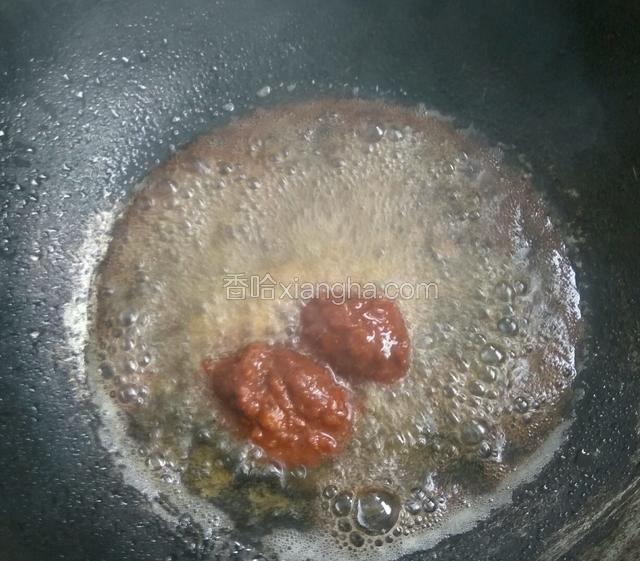 开火，放入适量油，放入豆瓣酱炸一下。